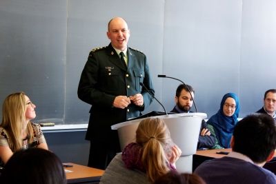 Photo by Julia Lim. Captain Alexander Parker, Law'09, speaks to students while his classmates and co-panelists Melissa Reiter, Jason Schmidt, Julie Lowe and Jason Sonshine look on.
