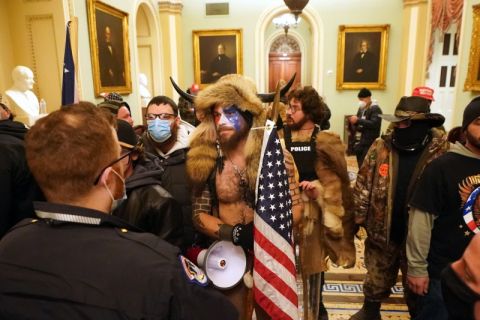 Members of the Proud Boys, one group among the hundreds of Trump supporters who violently stormed the U.S. Capitol in Washington on January 6, stand before police officers. Members of the Proud Boys, one group among the hundreds of Trump supporters who violently stormed the U.S. Capitol in Washington on January 6, stand before police officers.