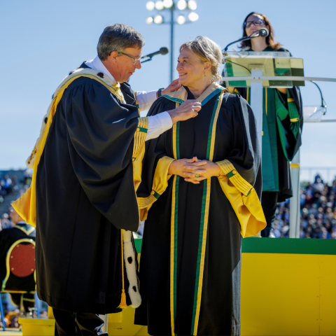 Queen’s Law Dean Colleen M. Flood receives her honorary Doctor of Laws hood from Université de Sherbrooke’s Rector Jean-Pierre Perreault before a crowd of 12,000 during the institutional convocation ceremony on Sept. 18. (Photo by Mathieu Lanthier)