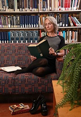 Professor Martha Bailey, LLM’88, curls up with a few good books, including The Laws of Adulterine Bastardy, in the Lederman Law Library. (Photo by Bernard Clark)