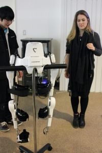 Meagan and a group member at Cyberdyne Studio test out a robotic body suit built to help frail elderly people lift objects and walk by sensing neurological signals.