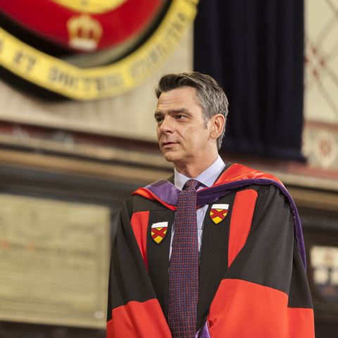 Professor Art Cockfield, Law’93, shown in his Stanford JSD gown onstage in Grant Hall at Law’s Spring Convocation 2015, has received posthumously this year’s H.R.S. Ryan Law Alumni Award of Distinction and Stanley M. Corbett Award for Teaching Excellence. (Photo by Greg Black)