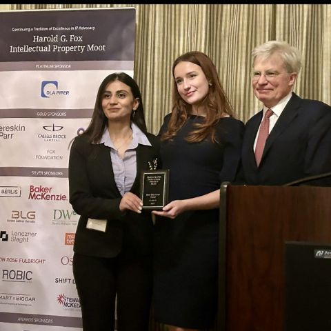 Nosheen Hotaki and Lauren Daly accept the Best Mooting Team award from Lord Kitchin of the Supreme Court of the United Kingdom.