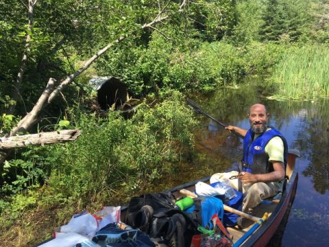Professor Noah Weisbord, on a canoe trip in La Verendrye Park, Quebec, prepares to avoid a portage by going through a culvert. 