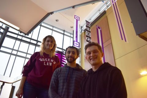 PBSC-Queen’s Akwesasne Self-Governance Project students Alina Smirnova, Anthony Gallo and Brandon Maracle in the Queen’s Law atrium that features a permanent art installation of historic Wampum belts. (Photo by Maggie Doherty) 
