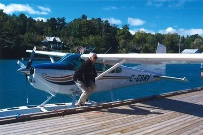 Jim Simmons steps off his tricolour floatplane to visit a client in Killarney, Ontario.