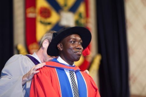 Tobi Moody at Spring Convocation 2017 in Grant Hall, where his PhD in Law degree is conferred, is hooded by then-Dean Bill Flanagan. (Photos by Greg Black)