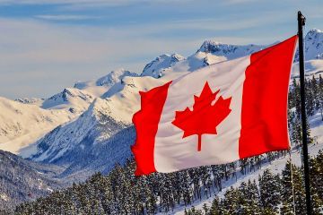 A photo of the Canadian flag in front of mountains