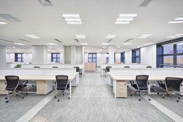 A photo of an empty office with multiple desks