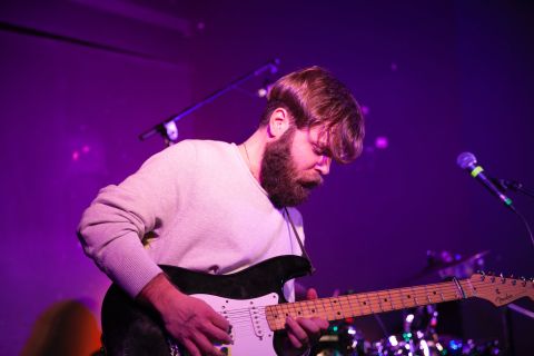 A young person plays guitar