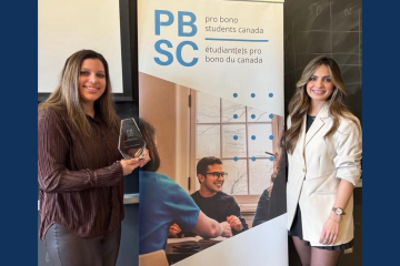 Bobbie Alvernaz Law’25, accepts Pro Bono Students Canada’s Chief Justice Richard Wagner Award from PBSC Coordinator Kira Petriello Law’25, at the Queen’s chapter’s volunteer appreciation event in the student lounge. 