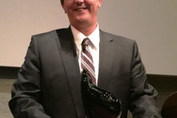 Ted Giesbrecht, Law’79, poses with his 2016 Coulter A. Osborne Award given by the Waterloo Region Law Association.