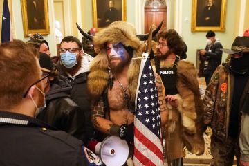 Members of the Proud Boys, one group among the hundreds of Trump supporters who violently stormed the U.S. Capitol in Washington on January 6, stand before police officers.