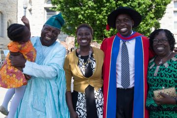 Tobi Moody, PhD’16, shown in his graduation cap and gown with family members after receiving his doctoral degree, is returning to Queen’s Law as the Queen’s National Scholar in International Economic Law. 