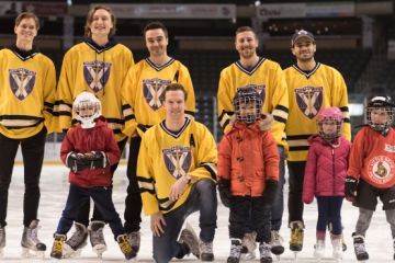 Members of the Queen’s Law men’s hockey team with Queen’s Law community children on the K-Rock Centre ice during the pre-game skate for the Winter Classic.